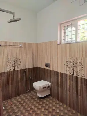 a bathroom with a toilet and a shower at Jacob's Homestay in Wayanad