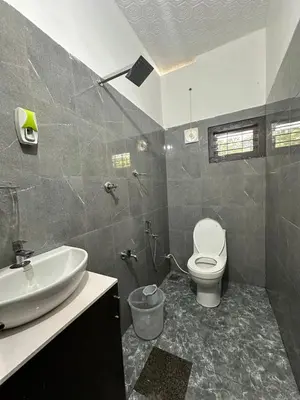 a bathroom with a sink and a toilet at Maryland homestay in Thattakād