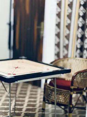 a ping pong table with two chairs in a room at Maryland homestay in Thattakād