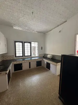 an empty kitchen with white walls and a ceiling at Maryland homestay in Thattakād