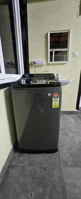 a black refrigerator in a room with a window at Premium Service apartment in Mysore