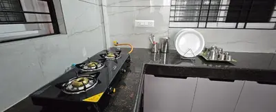a kitchen with a stove and a sink in it at Premium Service apartment in Mysore