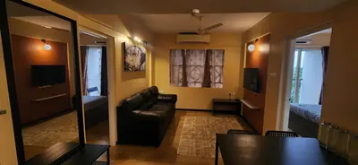 a living room with a couch and a bedroom at 2BR Flat with Pool and Balcony near Cochin Airport in Cochin