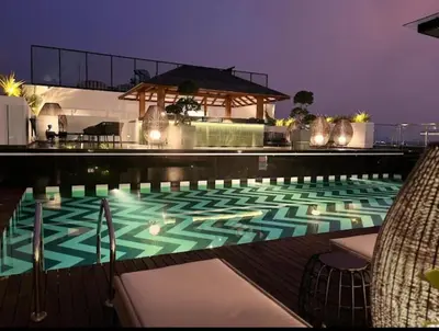 a swimming pool at night with a gazebo at 2BR Flat with Pool and Balcony near Cochin Airport in Cochin