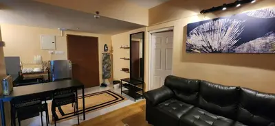 a living room with a black leather couch and a table at 2BR Flat with Pool and Balcony near Cochin Airport in Cochin