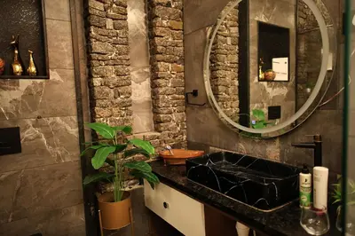 a bathroom with a black sink and a mirror at Ekta Pool Farmstay Pollachi in Pollāchi