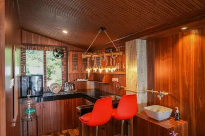 a kitchen with two red chairs and a sink at Le Karaj Meadows in Lovedale