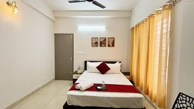 a bedroom with a bed with a red blanket at Nestora Suites in Kozhikode