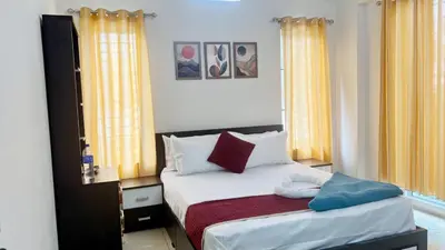 a bedroom with a bed with two pillows on it at Nestora Suites in Kozhikode