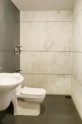 a bathroom with a toilet and a sink at Nestora Suites in Kozhikode