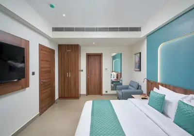 a hotel room with a bed and a television at REGAL HEIGHTS in Ernakulam