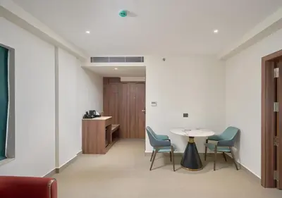 a room with a table and chairs and a desk at REGAL HEIGHTS in Ernakulam