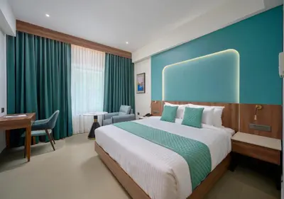 a hotel room with a large bed and a desk at REGAL HEIGHTS in Ernakulam