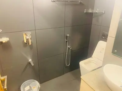 a bathroom with a shower with a toilet and a sink at Executive Room in Kelakam