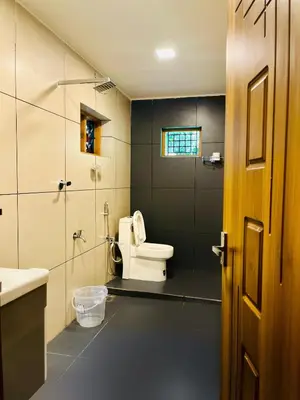 a bathroom with a toilet and a sink at Executive Room in Kelakam