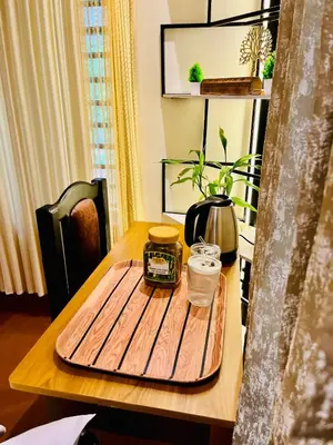a table with a wooden cutting board on top of it at Executive Room in Kelakam
