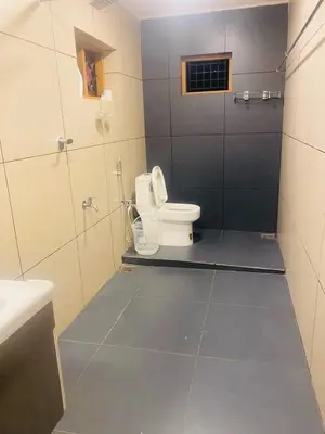 a bathroom with a toilet and a sink at Executive Room in Kelakam