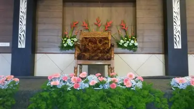 a chair with flowers in front of a building at Kohinoor Hotels in Erode