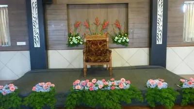a room with a chair and flowers on the floor at Kohinoor Hotels in Erode