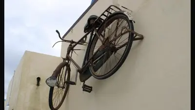 a bike hanging on the side of a wall at The Good Shepherd Cottage in Pollāchi