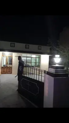 a person standing in front of a building at night at The Good Shepherd Cottage in Pollāchi
