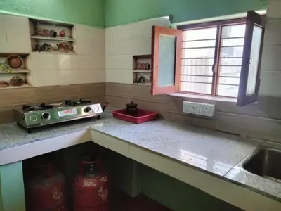 a kitchen with a counter and a sink and a window at The Good Shepherd Cottage in Pollāchi