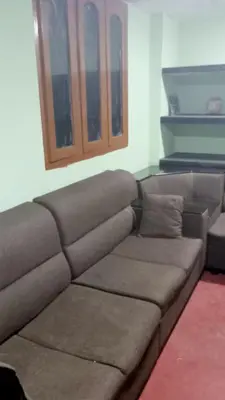 a brown couch sitting in a living room at The Good Shepherd Cottage in Pollāchi
