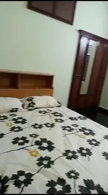 a bed with a comforter with flowers on it at Cloud Nine Home Thrissur in Trichūr