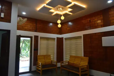 a dining room with two chairs and a ceiling fan at DreamWoods Cottage in Kelakam