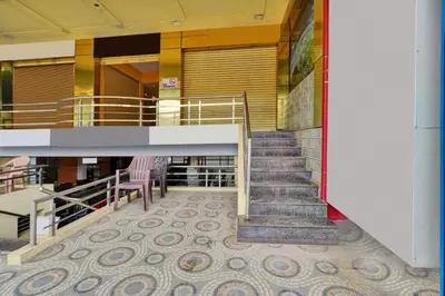 a stairway in a building with a staircase and chairs at Hotel O Kushal Nagar Near KSRTC Bus Stand in Kushālnagar