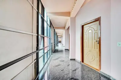 an empty corridor with a door in a building at Hotel O Coorg Hanging Bridge in Kushālnagar