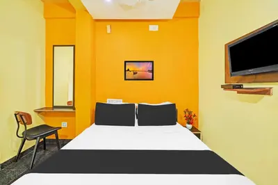 a bedroom with a bed and a flat screen tv at Hotel O Coorg Hanging Bridge in Kushālnagar