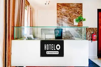 a hotel counter with a sign on it at Hotel O Mysuru Sand Museum in Mysore