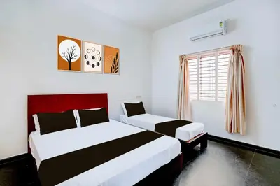 a bedroom with two beds and a window at Hotel O Mysuru Sand Museum in Mysore