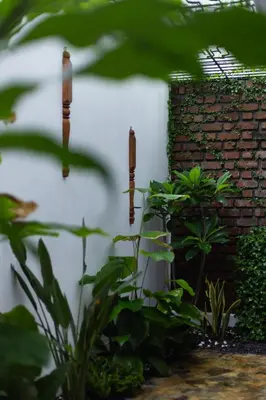 a brick wall with three candles in a garden at The Oneness Living- Seasonal Heritage stay with Tholpaavakoothu nights in Pazhayannūr