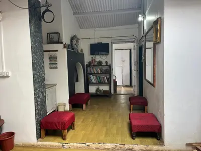 a hallway with red chairs and a book shelf at Bykerstops in Ooty