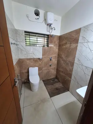 a bathroom with a toilet and a shower at Zainab Apartment in Perintalmanna
