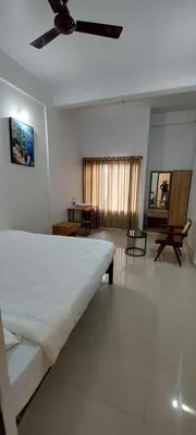 a bedroom with a bed and a ceiling fan at SAF RESIDENCY mukkam in Mukkam