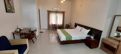 a hotel room with a bed and a table and chairs at SAF RESIDENCY mukkam in Mukkam