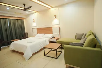a hotel room with a bed and a couch at AR Suites Kothamangalam in Kotamangalam