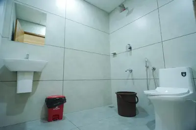 a white bathroom with a sink and a toilet at AR Suites Kothamangalam in Kotamangalam