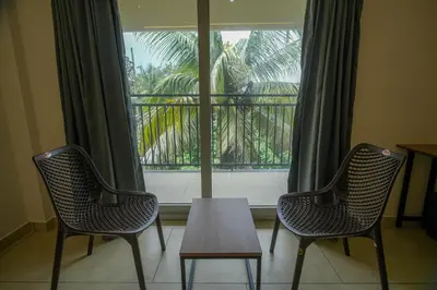 two chairs and a table in front of a window at AR Suites Kothamangalam in Kotamangalam