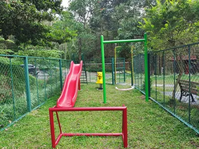 a playground with a red slide in a park at IRU Homes - Private Family Stay with Pool in Ambalavayal