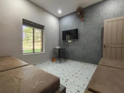 a bedroom with a bed and a flat screen tv at IRU Homes - Private Family Stay with Pool in Ambalavayal