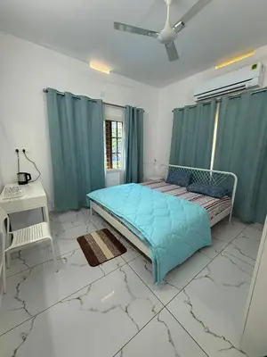 a bedroom with a blue bed in a room with marble floors at SRI Villa Rooms in Wayanad - Family Villa Stay with Mountain views in Vayittiri