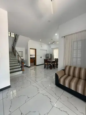 a living room with a couch and a table at SRI Villa Rooms in Wayanad - Family Villa Stay with Mountain views in Vayittiri