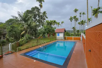 a swimming pool in the middle of a yard at Kudajadri Drizzle Homestay in Kaniyāmbetta