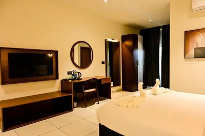 a hotel room with a bed with two swans on it at Hotel S S International Coorg in Suntikoppa