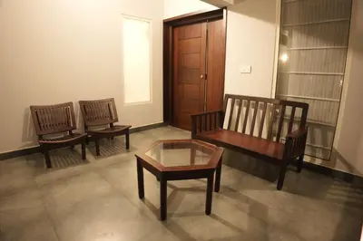 a living room with two chairs and a bench and a table at Coastline 4Bedroom cliffside villa in Elattūr