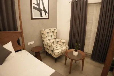 a bedroom with a bed and a chair and a table at Coastline 4Bedroom cliffside villa in Elattūr